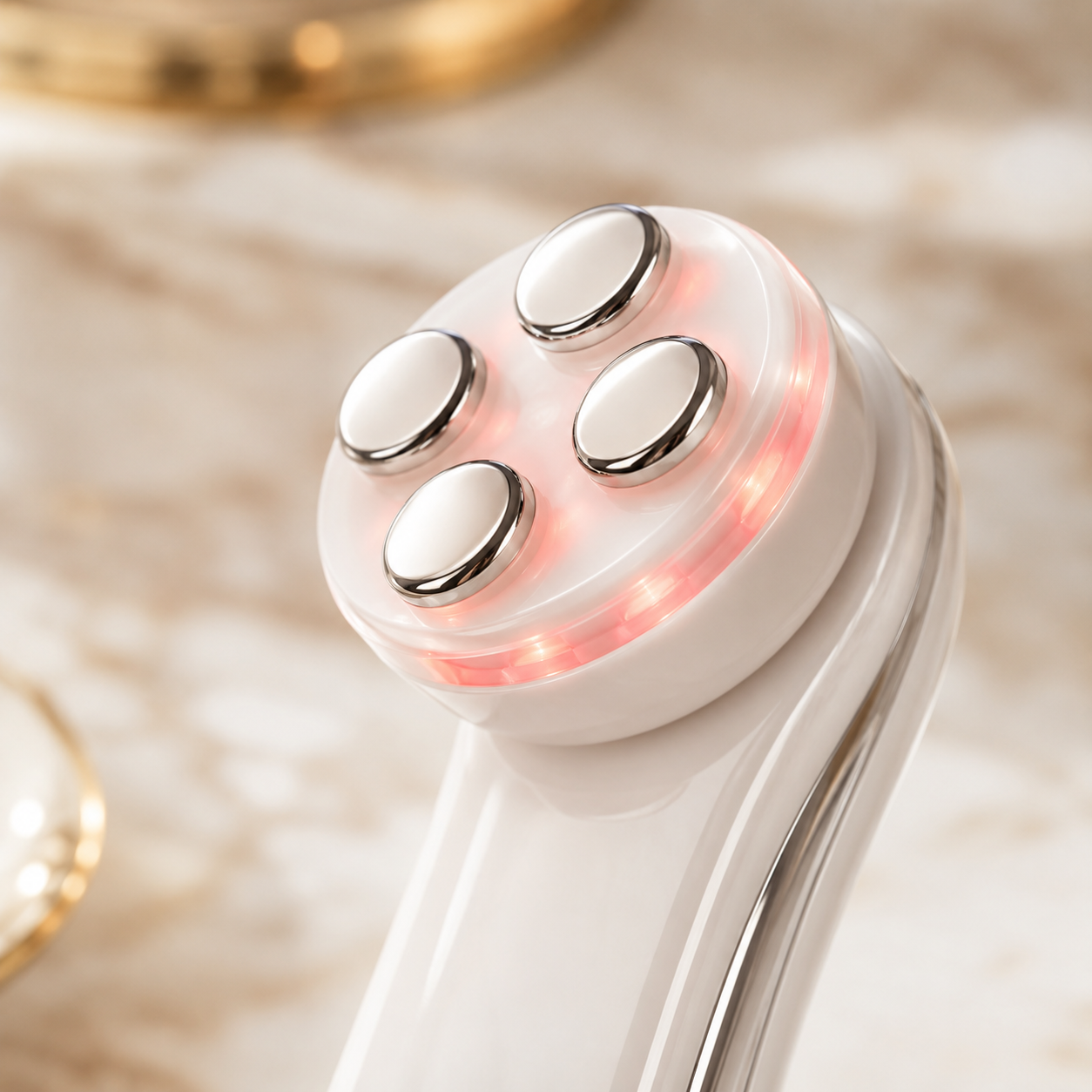 Close-up of the LumiFirm treatment head with four polished electrodes and LED glow
